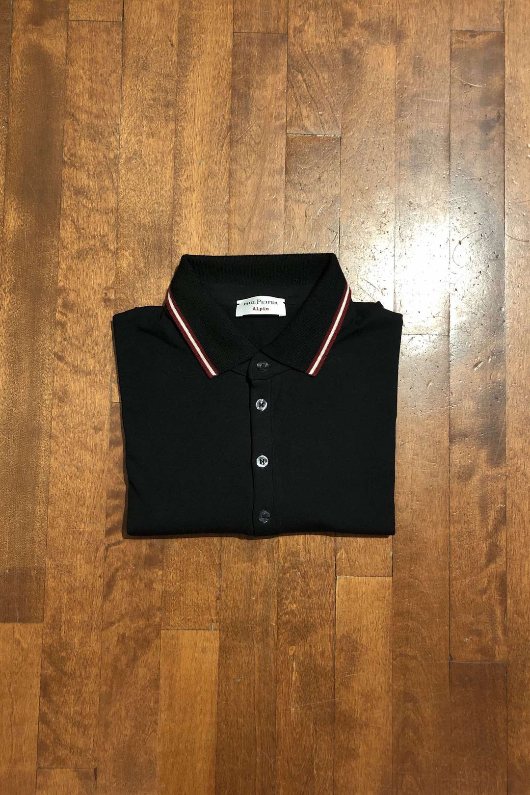 Polo manches longues noir Phil Petter avec collet rouge et blanc, confectionné en viscose et élasthanne.