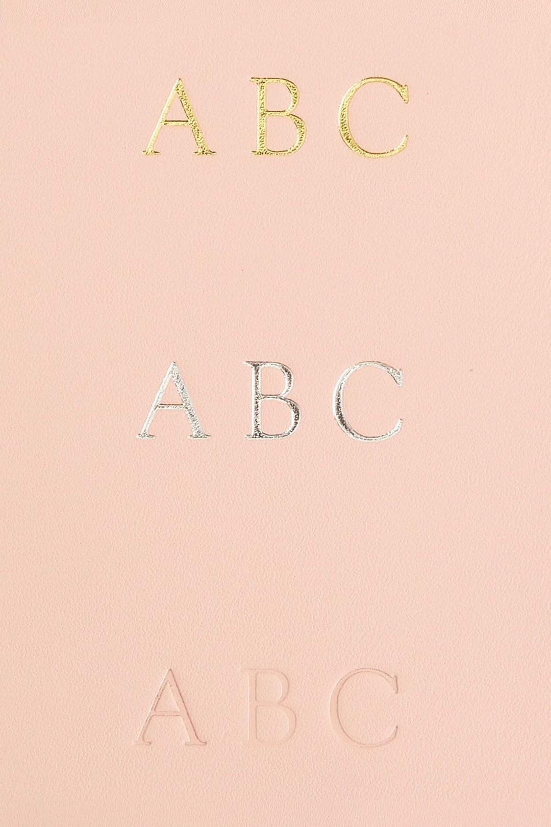 Monogrammage en cuir Nappa avec lettres dorées, argentées et en relief, sur un fond rose.