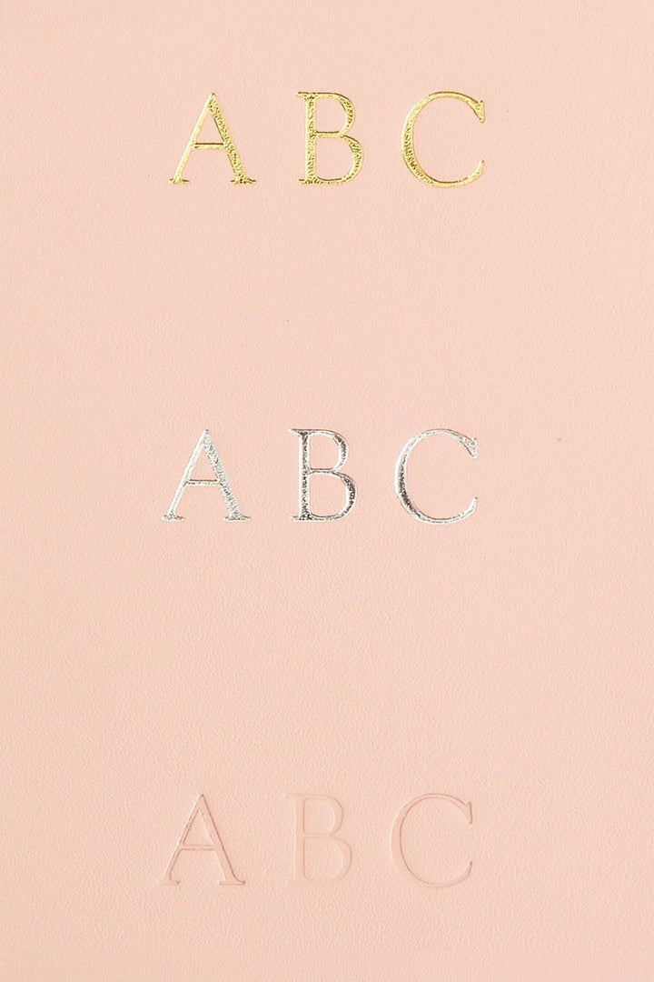 Monogrammage en cuir Nappa avec lettres dorées, argentées et en relief, sur un fond rose.