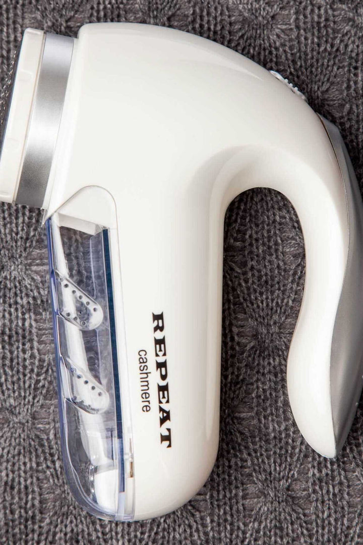 Rasoir à laine électrique pour enlever bouloches et fibres, avec récipient transparent et brosse de nettoyage incluse.