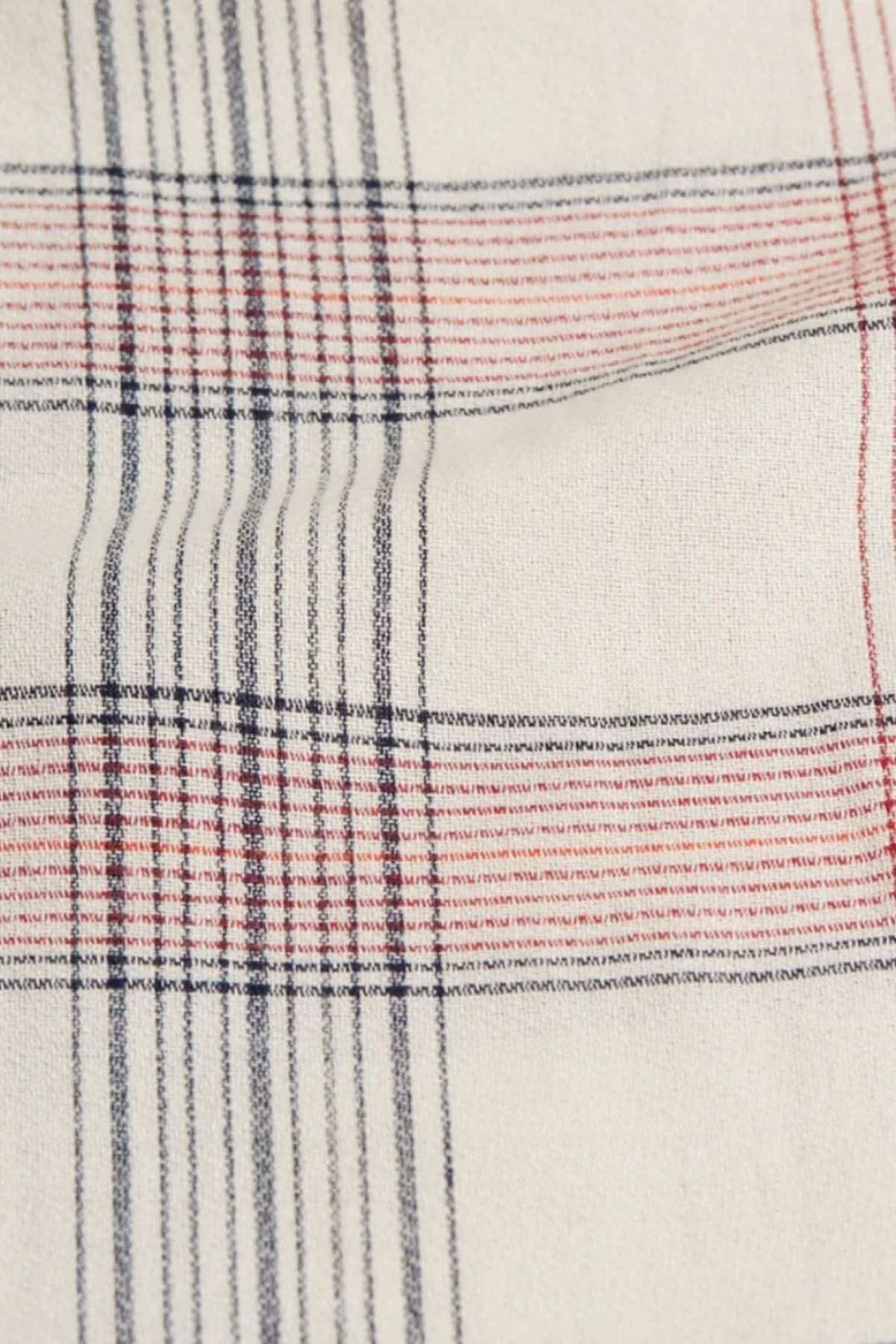 Motifs à carreaux en beige, rouge et noir sur un tissu léger et confortable.