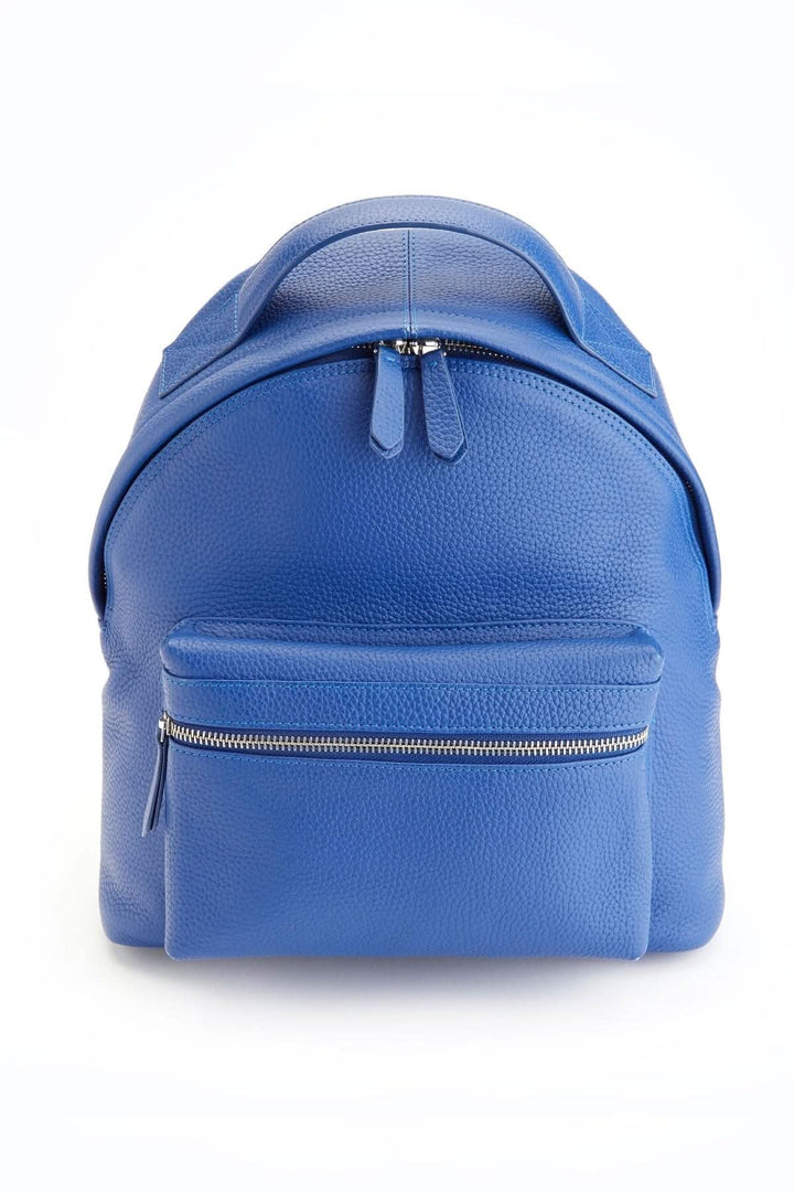 Sac à dos de voyage compact en cuir bleu, avec compartiment pour tablette et zip avant.