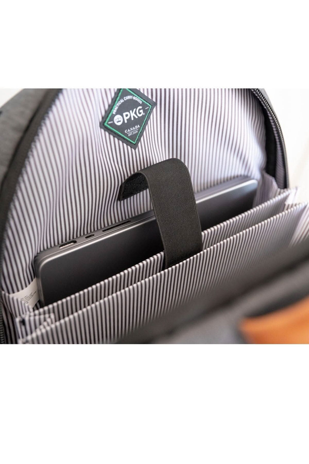 Intérieur du sac à dos Durham Outpost 30L montrant une tablette dans une poche organisée.