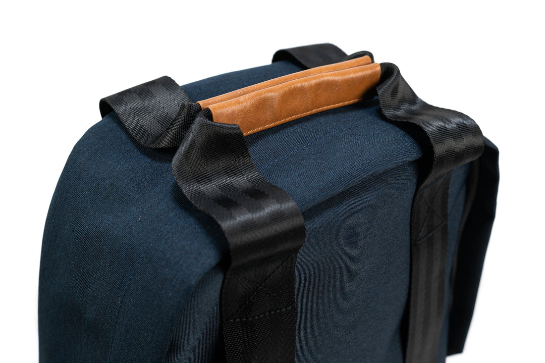 Détail du sac à dos PKG Rosseau recyclé 19L, montrant les poignées en cuir et les bretelles noires.