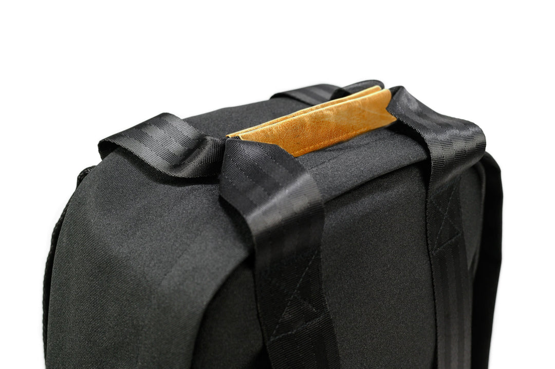 Détail du sac à dos PKG Rosseau recyclé 19L, montrant la poignée supérieure et les bretelles robustes.