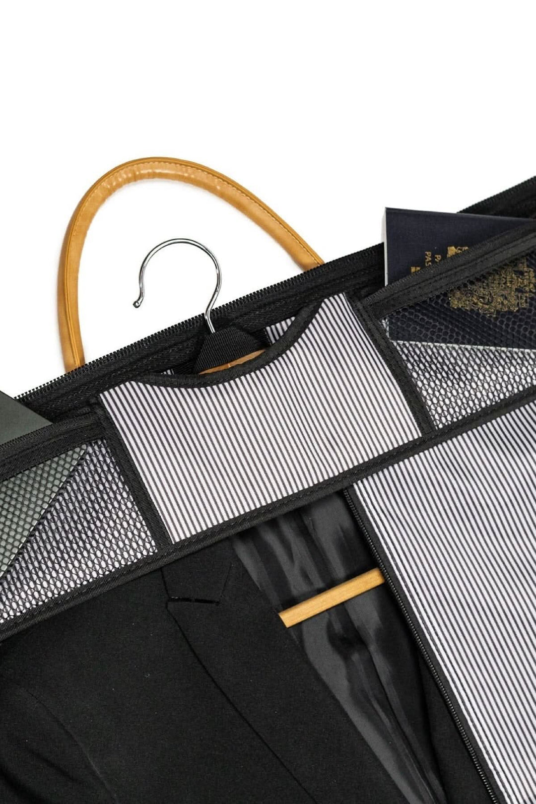 Intérieur d'une housse de costume avec un costume noir suspendu sur un cintre en bois.