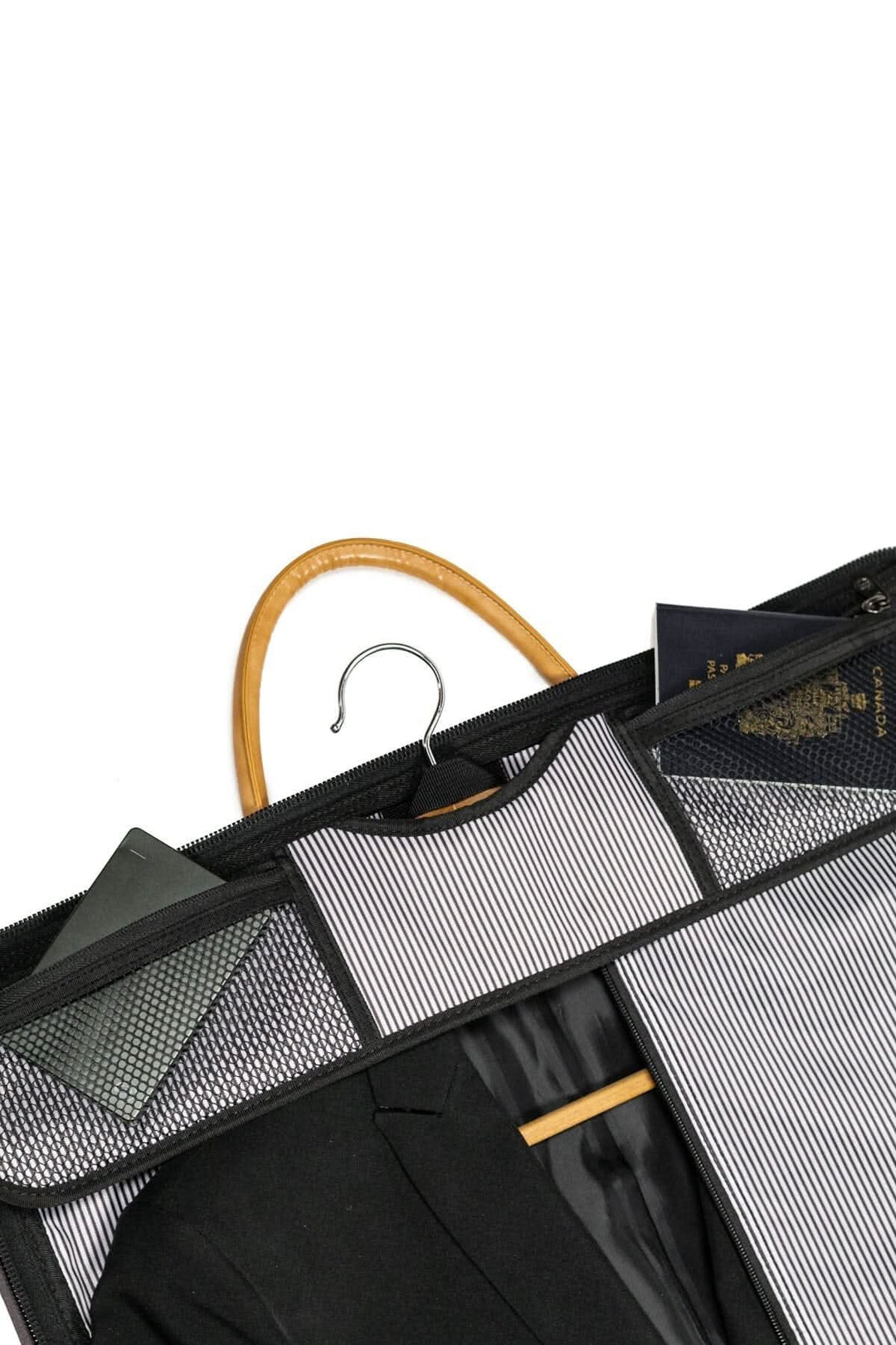 Intérieur d'une housse de costume avec un costume noir, passeport et documents, idéal pour le voyage.