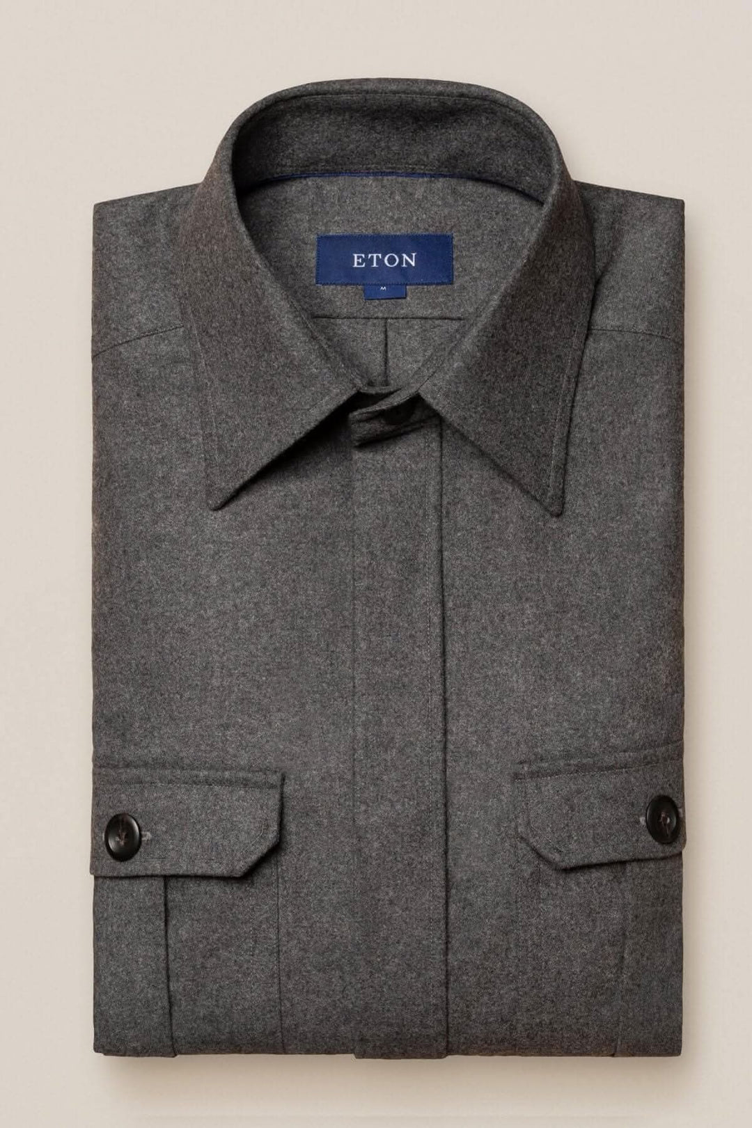 Surchemise en laine cachemire grise de marque ETON, élégamment pliée avec poches et col classique.