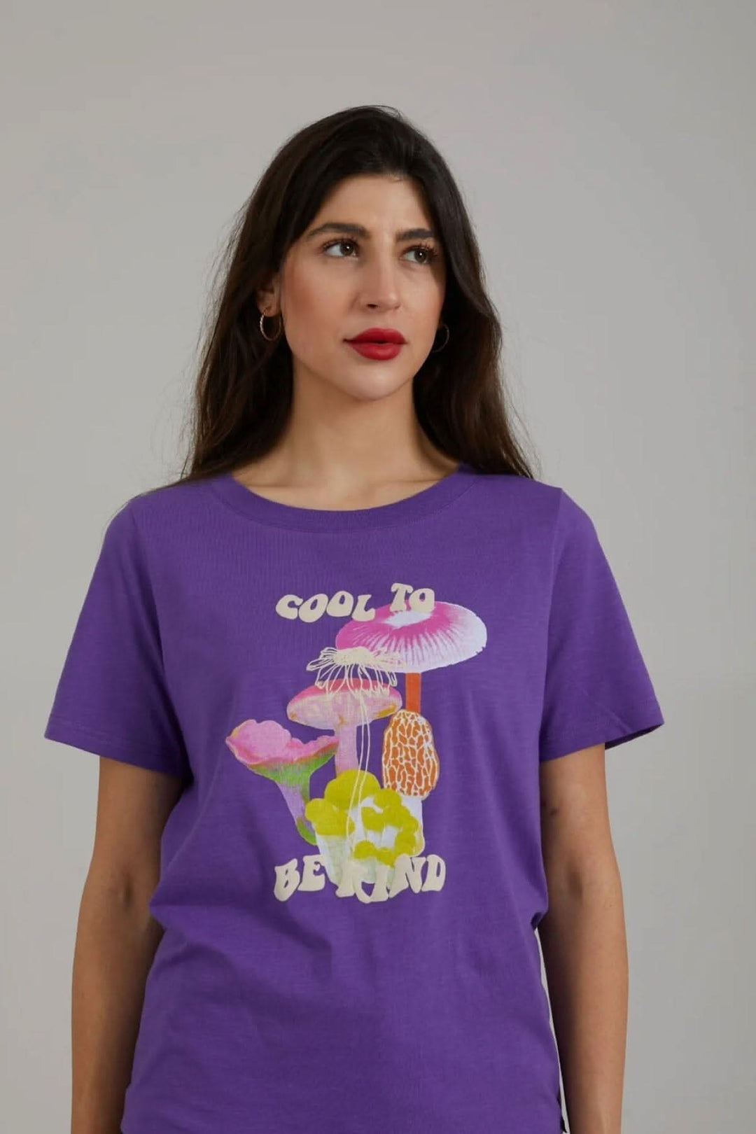 T-shirt violet avec imprimé de champignons colorés et slogan "Cool to be kind", manches courtes, encolure ronde.