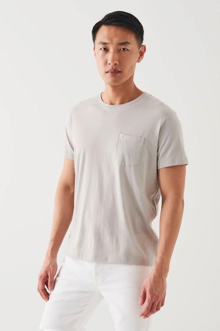 Homme portant un t-shirt léger en coton pima, couleur beige, avec poche. Idéal pour temps chaud.