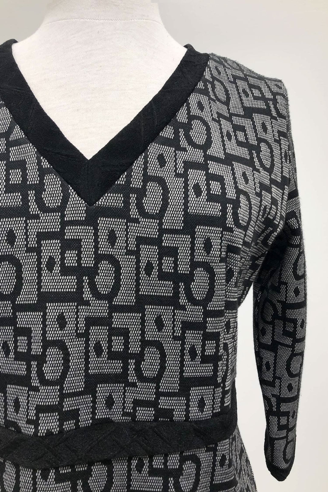 Tunique grise et noire à motifs, col en V et manches trois-quart, fabriquée au Québec.