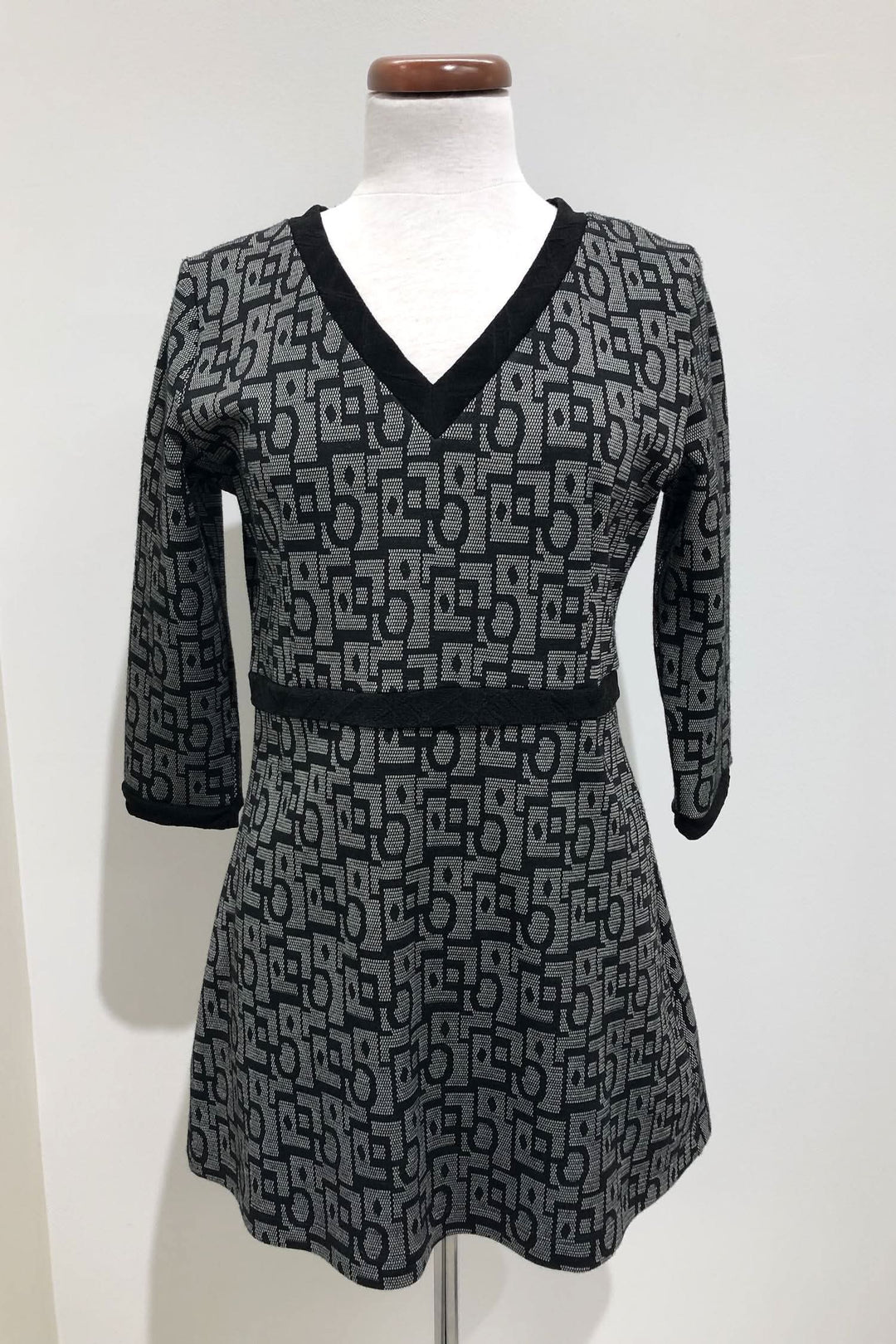 Tunique grise et noire à motifs géométriques, col en V, manches trois-quart, fabriquée au Québec.