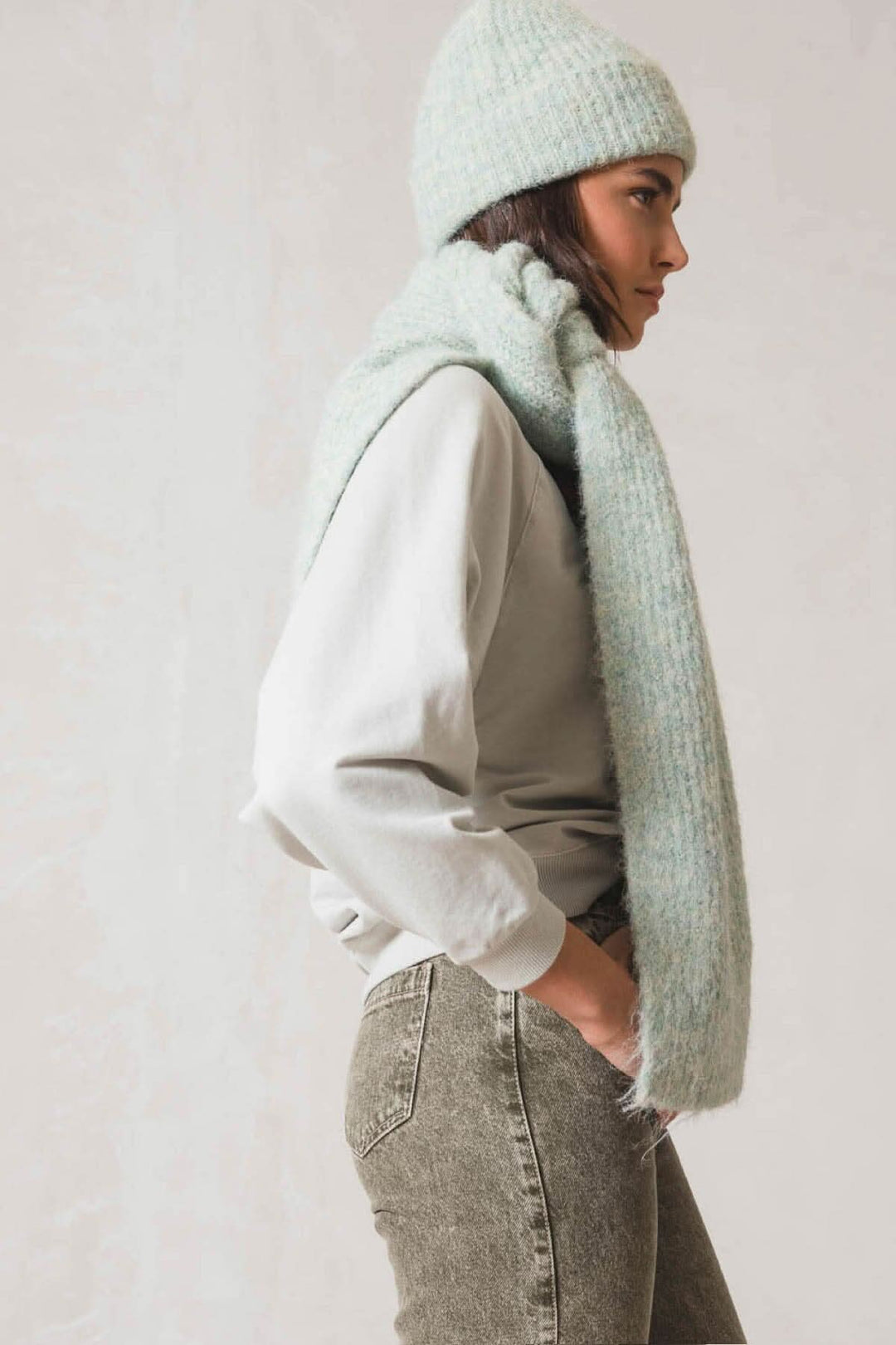 Femme portant une tuque en tricot douce et une écharpe assortie, parfaite pour les journées fraîches.