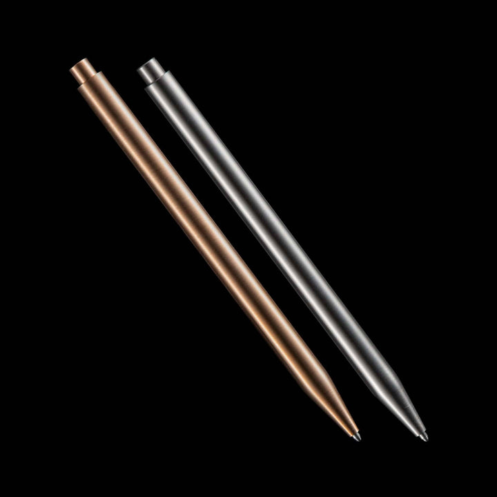 Deux stylos modernes en bronze et acier inoxydable sur fond noir, parfaits pour un style élégant.