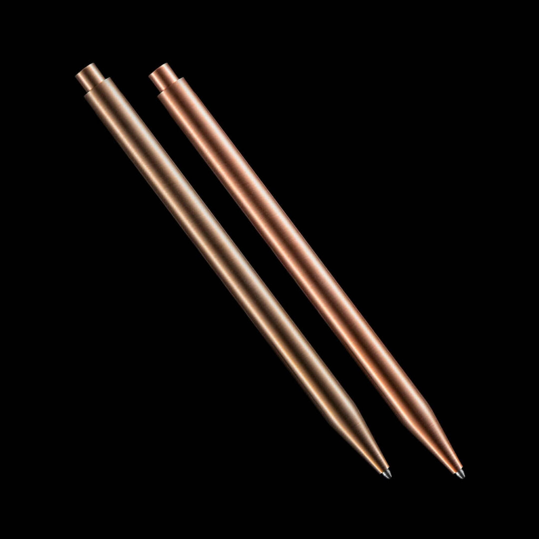 Deux stylos modernes en métal : un en bronze et un en cuivre, au design élégant.