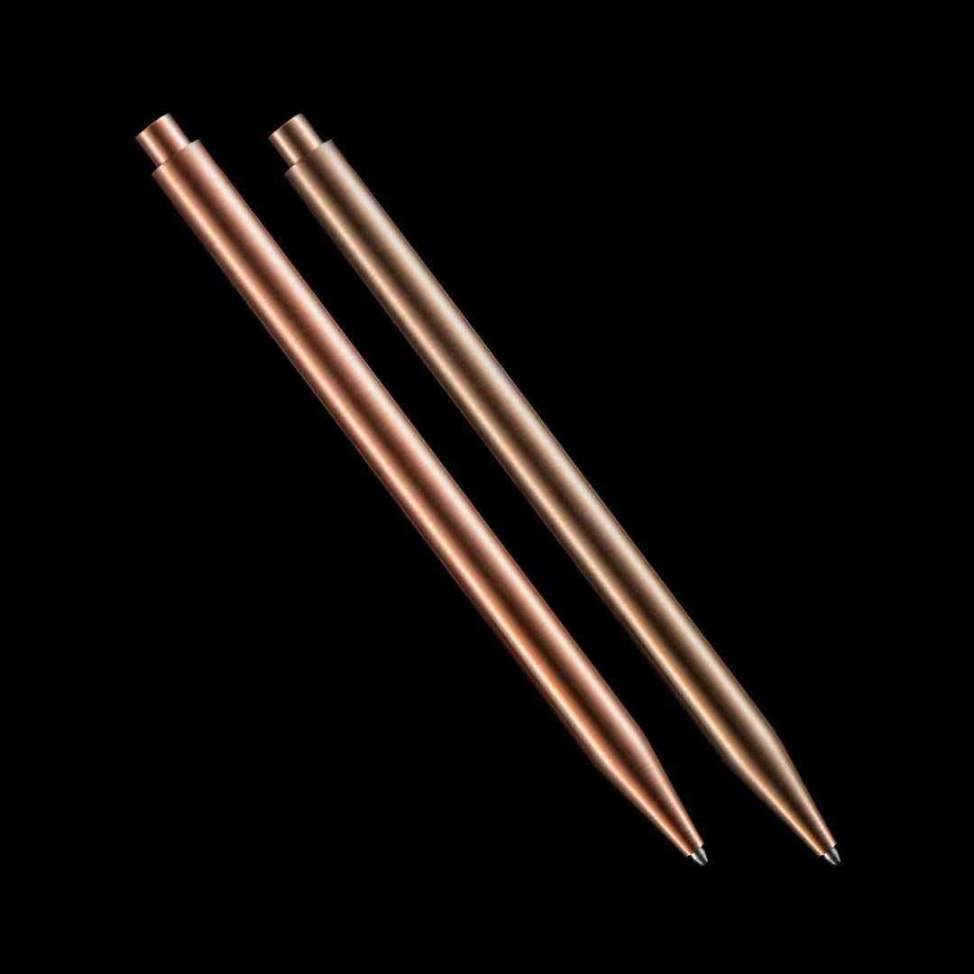 Deux stylos modernes en cuivre et bronze sur fond noir, alliant élégance et fonctionnalité.