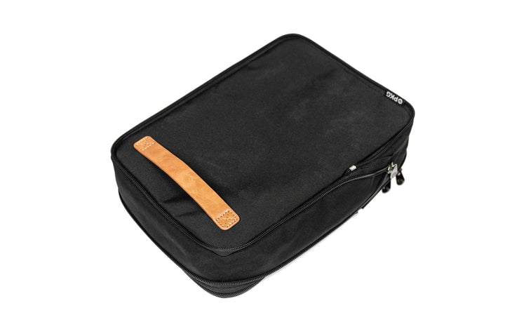 Union recycled compression packing cube in black with leather accent, zippered for efficient packing and organization.
