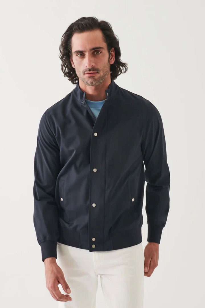 Homme portant une veste bomber en nylon bleu marine, au style moderne et confortable.