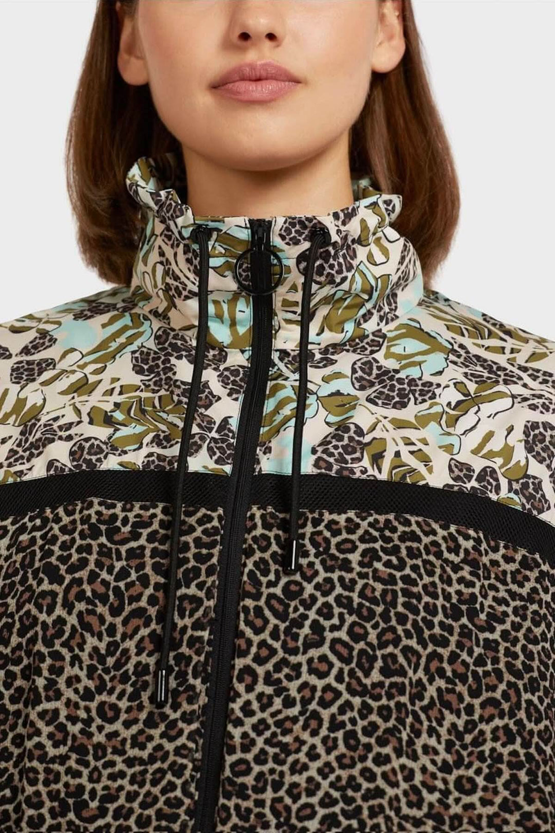 Veste féminine à motifs patchwork avec col montant et cordon, élégante et sportive.