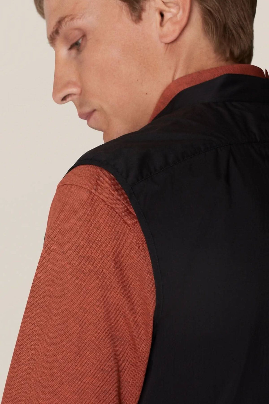 Homme portant une veste sans manches déperlante, style contemporain, classique pour la superposition.