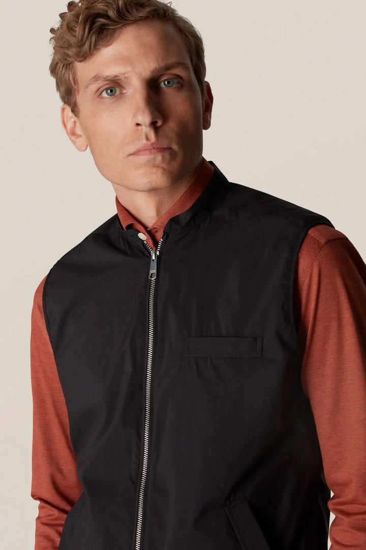 Homme portant une veste sans manche déperlante, élégante, parfaite pour la superposition et le style extérieur.