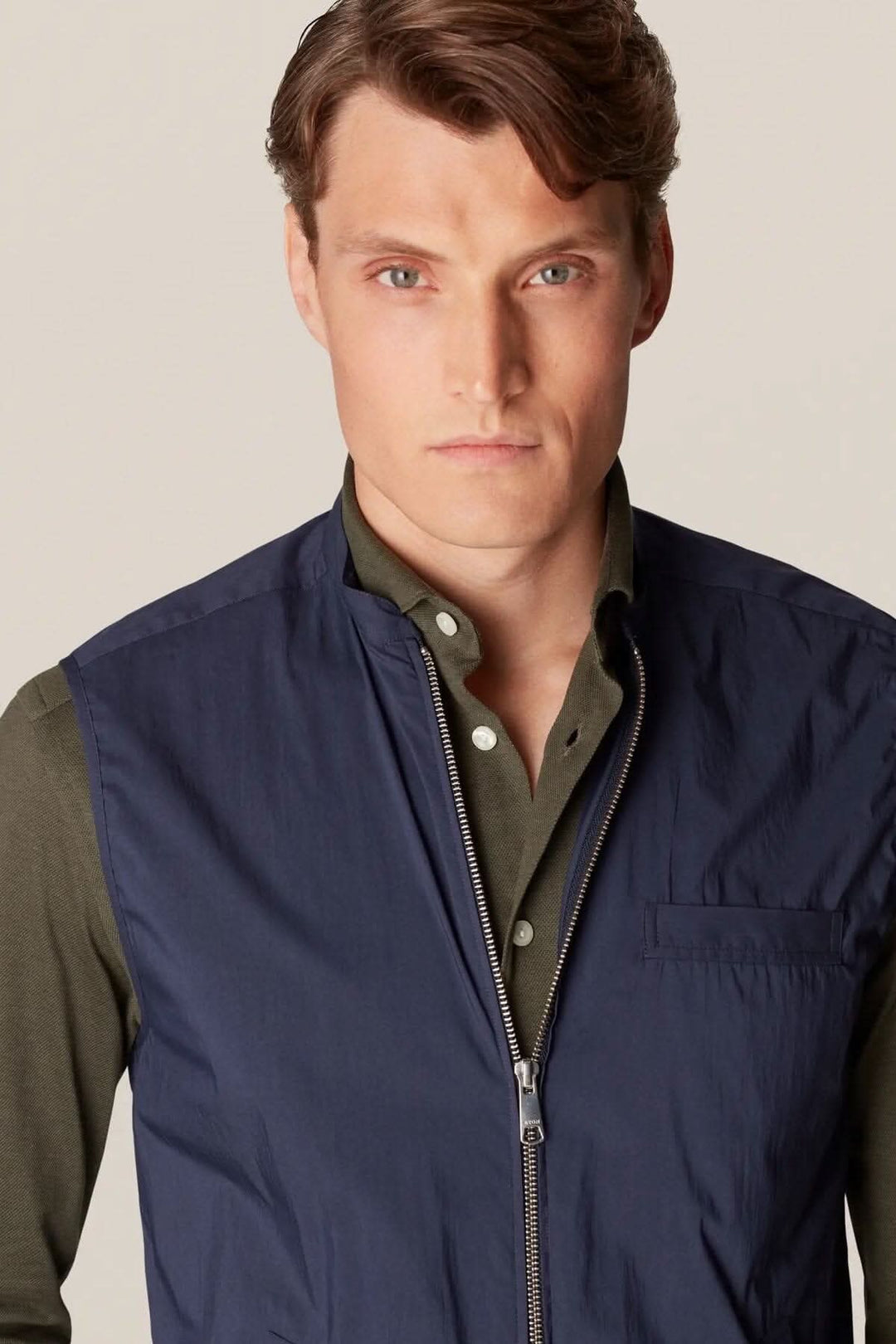 Homme portant une veste sans manches élégante, déperlante et contemporaine, parfaite pour la superposition.